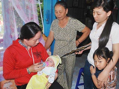 B&eacute; Nguyễn Quốc Huy trong v&ograve;ng tay những người th&acirc;n Ảnh: THANH V&Acirc;N
