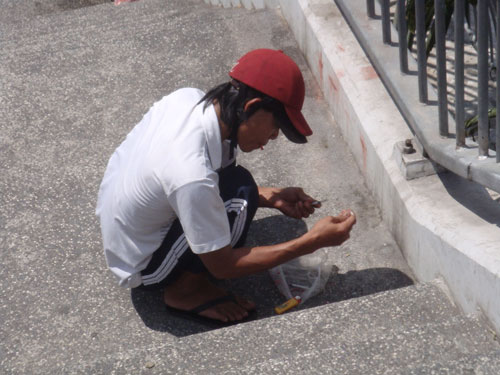 Một người nghiện đang ch&iacute;ch ma t&uacute;y ngay cầu thang bộ h&agrave;nh tr&ecirc;n cầu Ch&agrave; V&agrave; Ảnh: T&Acirc;N TIẾN