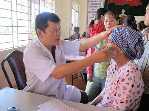 Bác sĩ đang khám bệnh cho một phụ nữ dân tộc S’tiêng