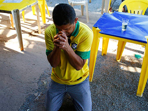 Một CĐV Brazil cầu nguyện khi đội nhà tranh tài với Chile ở loạt sút luân lưu 11 m rạng sáng 29-6 Ảnh: REUTERS