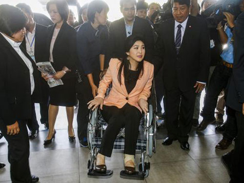 Thủ tướng tạm quyền Yingluck Shinawatra ngồi xe lăn đến dự cuộc họp nội các hôm 18-3 Ảnh: Reuters