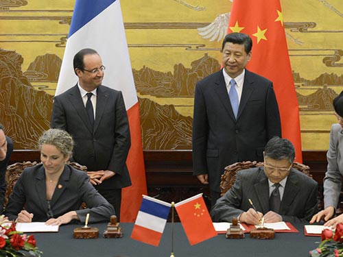 Tổng thống Ph&aacute;p Francois Hollande (đứng, b&ecirc;n tr&aacute;i) v&agrave; Chủ tịch Trung Quốc Tập Cận B&igrave;nh chứng kiến lễ k&yacute; thỏa thuận hợp t&aacute;c Ảnh: REUTERS