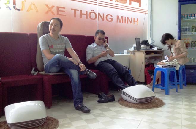 Kh&aacute;ch h&agrave;ng rửa xe được thoải m&aacute;i ngồi chờ với nước uống v&agrave; m&aacute;y m&aacute;t-xa ch&acirc;n miễn ph&iacute;.