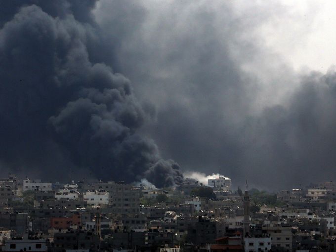 Xe tăng Israel tấn công vào khu vực Shijaiyah ở Dải Gaza hôm 20-7, giết chết ít nhất 99 người Palestine. Ảnh: Reuters, EPA