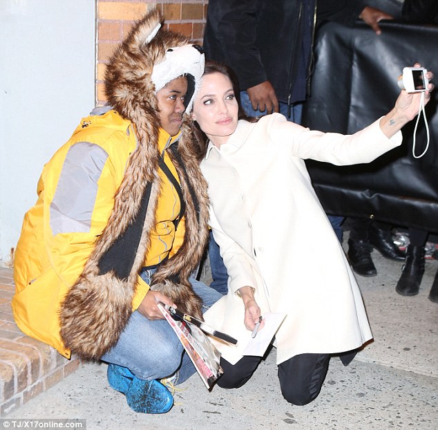 Angelina Jolie quỳ xuống s&agrave;n vỉa h&egrave;, an ủi v&agrave; chụp ảnh c&ugrave;ng một người h&acirc;m mộ