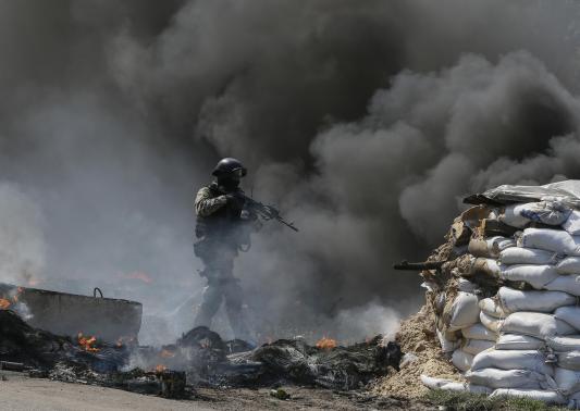 Binh sĩ Ukraine tiến gần một chốt chặn của phe ly khai gần Slavyansk hôm 24-4. Ảnh: Reuters
