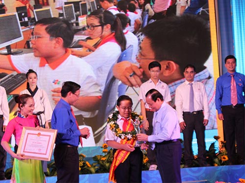Bí thư Thành ủy TP HCM Lê Thanh Hải (bìa phải) trao danh hiệu Công dân trẻ tiêu biểu cho em Nguyễn Dương Kim Hảo, học sinh Trường THCS Nguyễn Gia Thiều, quận Tân Bình