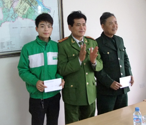 T&agrave;i xế taxi Nguyễn Minh Ho&agrave;ng (b&igrave;a tr&aacute;i), từ chối hối lộ 10 triệu đồng của t&ecirc;n si&ecirc;u trộm được l&atilde;nh đạo c&ocirc;ng an TP Thanh H&oacute;a trao thưởng.