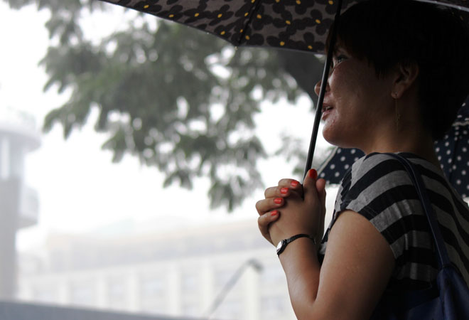 Một người dân đứng ngắm Thương xá ngày cuối cùng trong con mưa rào.