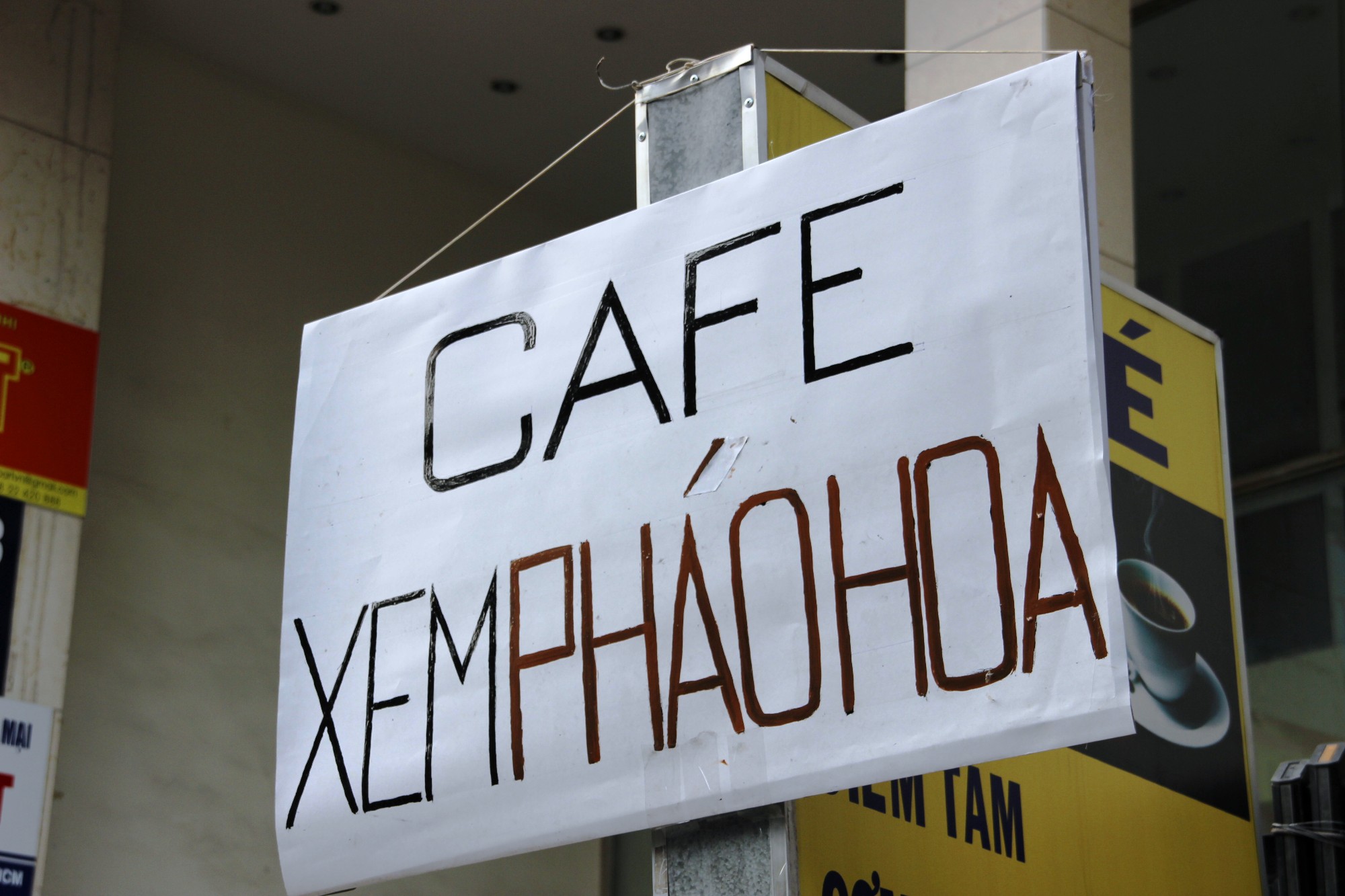 Một qu&aacute;n c&agrave; ph&ecirc; treo bảng phục vụ kh&aacute;ch xem ph&aacute;o hoa.