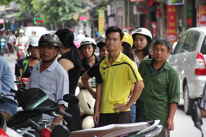 D&atilde;y người xếp h&agrave;ng tr&agrave;n cả ra l&ograve;ng đường. Nhiều người vẫn đ&ocirc;i nguy&ecirc;n mũ bảo hiểm để nhanh ch&acirc;n xếp h&agrave;ng chờ tới lượt.