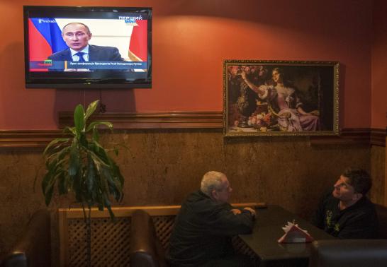Người d&acirc;n Kiev theo d&otilde;i cuộc họp b&aacute;o của Tổng thống Nga Putin h&ocirc;m 4-3. Ảnh: Reuters