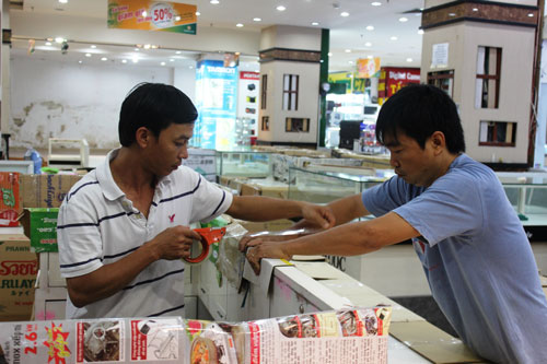 Tiểu thương thu dọn quầy kệ trong ngày cuối cùng của Thương xá Tax Ảnh: LÊ PHONG