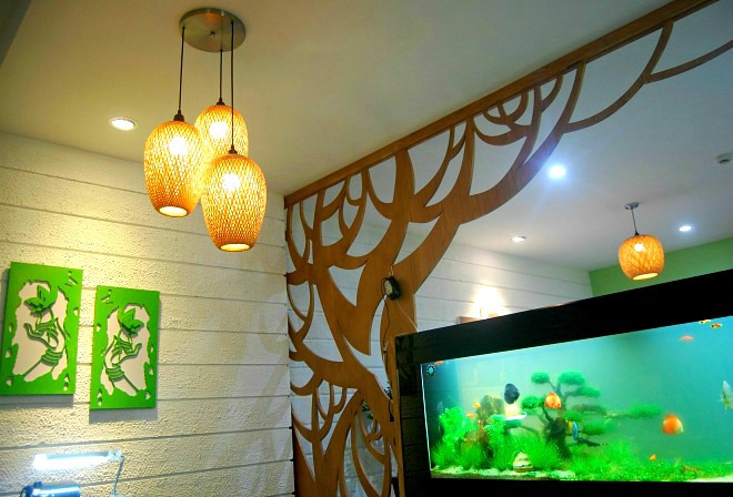 Hồ c&aacute; thủy sinh ngăn giữa ph&ograve;ng kh&aacute;ch v&agrave; khu vực ăn uống trở th&agrave;nh v&aacute;ch ngăn tự nhi&ecirc;n v&agrave; thu h&uacute;t. Gia chủ sử dụng hồ c&aacute; kh&ocirc;ng chỉ l&agrave; yếu tố trang tr&iacute; đơn thuần m&agrave; phần n&agrave;o khắc chế sự n&oacute;ng t&iacute;nh khi bước về nh&agrave;.