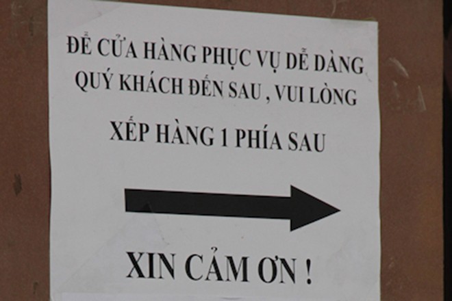 Biển nhắc nhở kh&aacute;ch h&agrave;ng xếp h&agrave;ng chờ mua b&aacute;nh được d&aacute;n trước cửa h&agrave;ng.