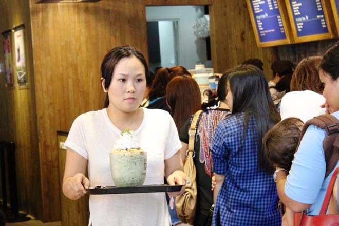 Một khách hàng đang cố gắng tìm một vị trí ngồi sau khi mua được ly cà phê khổng lồ