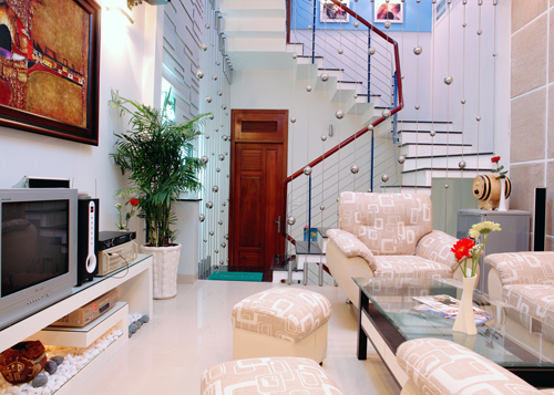 Kệ tivi trong phòng khách cũng là bê tông ốp gỗ; vị trí phòng khách cũng cho thấy ưu điểm của nhà lệch tầng tạo nên những view nhìn hấp dẫn hơn.