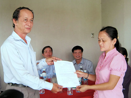 Đại diện CĐ Gi&aacute;o dục TP (tr&aacute;i) trao quyết định tặng nh&agrave; cho gi&aacute;o vi&ecirc;n c&oacute; ho&agrave;n cảnh đặc biệt kh&oacute; khăn
