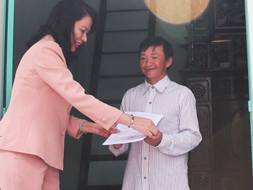 B&agrave; Nguyễn Thị Thu, Chủ tịch LĐLĐ TP HCM, trao quyết định tặng nh&agrave; cho anh Nguyễn Văn Ch&iacute;nh