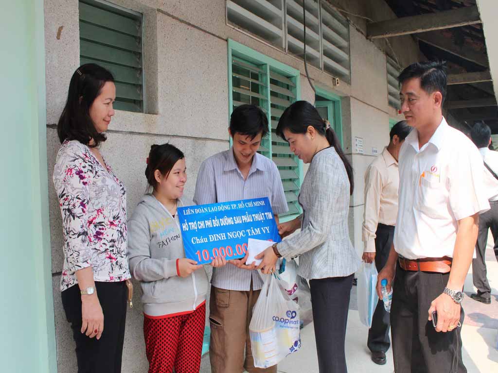 B&agrave; Nguyễn Trần Phượng Tr&acirc;n, Ph&oacute; Chủ tịch LĐLĐ TP (thứ hai từ phải sang), trao tiền cho gia đ&igrave;nh anh Hiếu