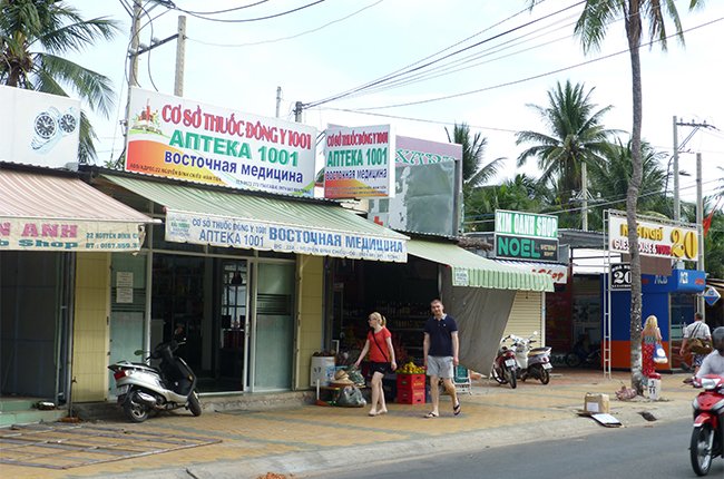 Du kh&aacute;ch Nga đi ngang những cửa h&agrave;ng c&oacute; bảng hiệu bằng tiếng Nga ở H&agrave;m Tiến, Phan Thiết. Lượng kh&aacute;ch Nga đang sụt giảm khiến nhiều kh&aacute;ch sạn, nh&agrave; h&agrave;ng ở đ&acirc;y kinh doanh kh&oacute; khăn hơn trước - Ảnh: Đ&agrave;o Loan