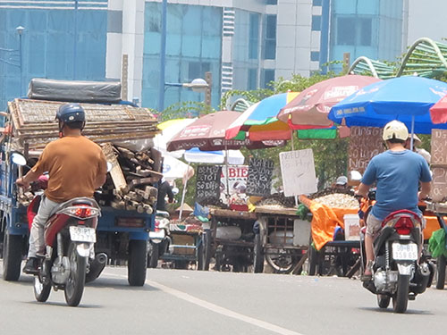 Xe th&ocirc; sơ, tự chế b&aacute;n hải sản đậu d&agrave;y đặc tr&ecirc;n cầu Tham Lương, quận 12, TP HCM Ảnh: PHẠM DŨNG