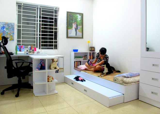 G&oacute;c l&agrave;m việc c&oacute; tủ thiết kế th&agrave;nh nhiều &ocirc; để đựng đồ trang tr&iacute;. Chiếc giường trắng c&oacute; thể k&eacute;o ra đủ chỗ cho hai người nằm v&agrave; c&oacute; thể dựng l&ecirc;n hay chuyển sang ph&ograve;ng kh&aacute;c.