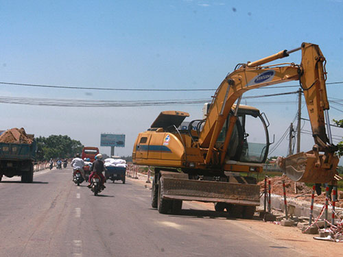 C&aacute;c phương tiện phục vụ cho việc thi c&ocirc;ng Quốc lộ 1 qua địa phận tỉnh Quảng Nam đậu ngổn ngang g&acirc;y kh&oacute; khăn cho người tham gia giao th&ocirc;ng      Ảnh: QUANG VINH