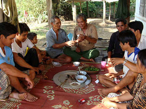 Trưởng th&ocirc;n Phạm Văn Lang (người cầm ly rượu ở giữa) trong một buổi h&ograve;a giải cho 
cặp vợ chồng trẻ th&ocirc;n Măng Đen Ảnh: TỬ TRỰC