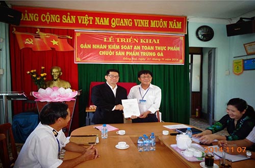 &Ocirc;ng Nguyễn Hữu Danh (&aacute;o trắng), đại diện Chi cục Quản l&yacute; chất lượng n&ocirc;ng l&acirc;m sản v&agrave; thủy sản Đồng Nai, trao giấy x&aacute;c nhận &ldquo;Sản phẩm được kiểm so&aacute;t an to&agrave;n thực phẩm theo chuỗi&rdquo; cho &ocirc;ng Thunya Wealuvan, Gi&aacute;m đốc ng&agrave;nh trứng gia cầm CP Việt Nam