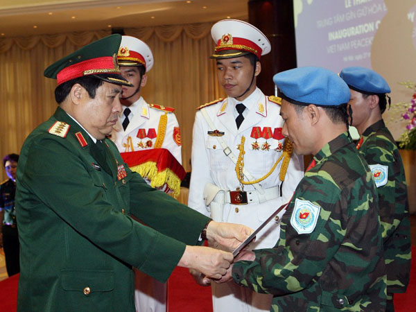 Bộ trưởng Ph&ugrave;ng Quang Thanh trao quyết định, mũ nồi xanh cho 2 sĩ quan l&agrave;m nhiệm vụ g&igrave;n giữ h&ograve;a b&igrave;nh LHQ tại Nam Sudan