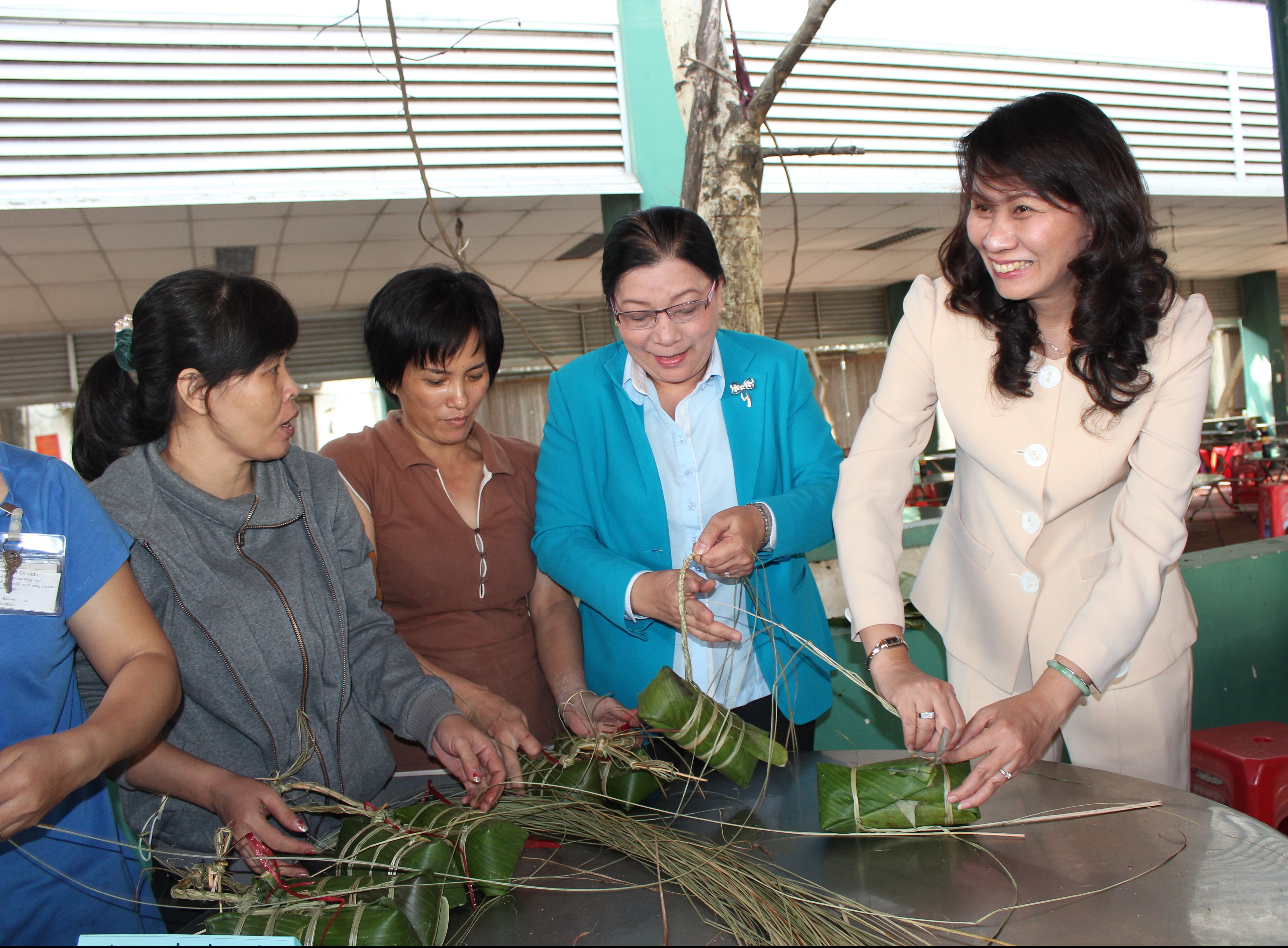 B&agrave; Nguyễn Thị Thu, Chủ tịch LĐLĐ TP (phải) v&agrave; b&agrave; Nguyễn Thị B&iacute;ch Thủy, Ph&oacute; Chủ tịch LĐLĐ TP (thứ hai, b&ecirc;n phải) g&oacute;i b&aacute;nh t&eacute;t c&ugrave;ng c&ocirc;ng nh&acirc;n
