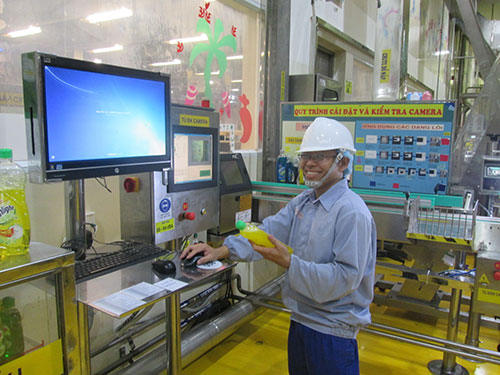 Anh Nguyễn Đo&agrave;n Vi b&ecirc;n d&acirc;y chuyền d&aacute;n nh&atilde;n tự động do anh cải tiến