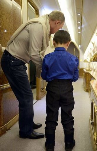 Ông Putin đã tặng con trai của cố quân nhân một chiếc xe điều khiển. Ảnh: Ria Novosti