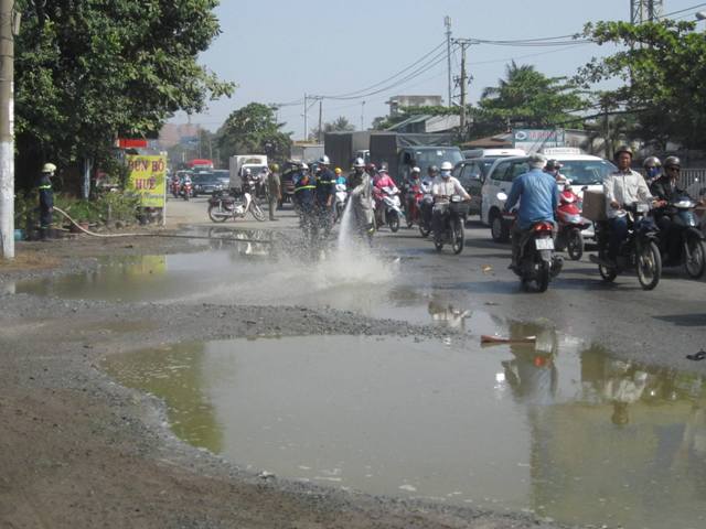 Lực lượng chức năng phải xịt nước để rửa sạch h&oacute;a chất tr&ecirc;n đường