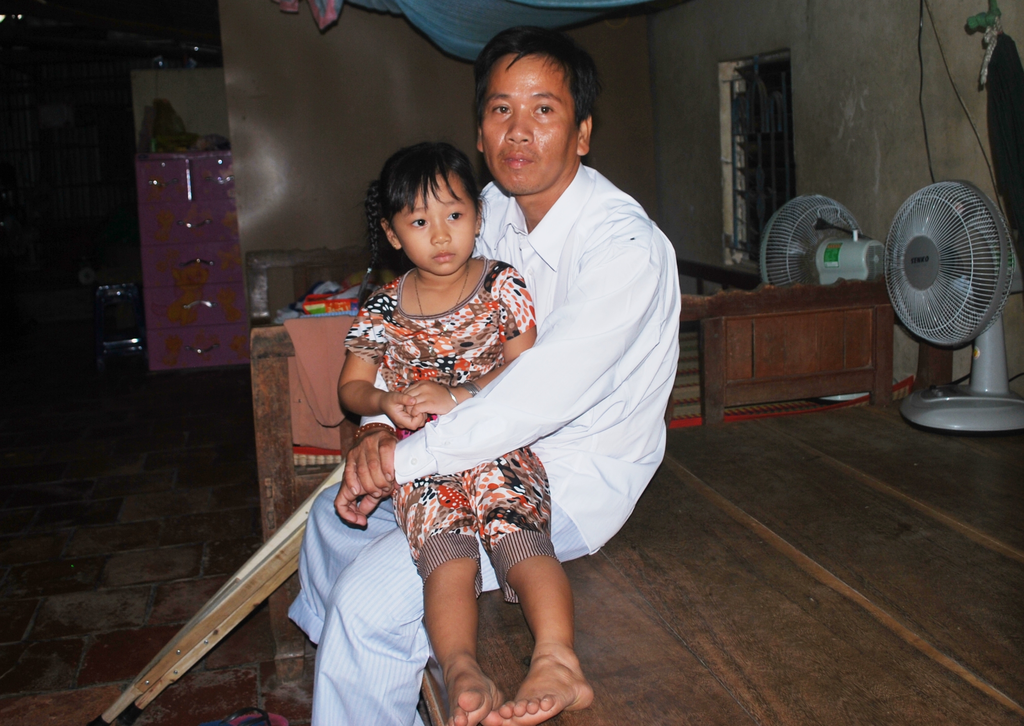 Bé Nguyễn Thị Kim Huyền (5 tuổi, con gái chị Ngọc) bên vòng tay ấm áp của cha.
