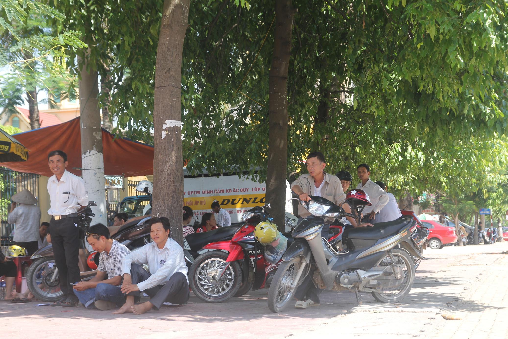 Người nh&agrave; &ldquo;đội nắng&rdquo; chờ c&aacute;c thi sinh l&agrave;m b&agrave;i. Ảnh: Đức Ngọc