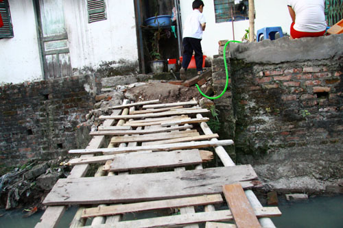 Để v&agrave;o được nh&agrave;, nhiều hộ d&acirc;n thuộc Tổ 9  thuộc phường Ngọc H&agrave; đ&atilde; phải tự chế những chiếc cầu ọp ẹp từ nhiều mảnh gỗ cốp pha đ&atilde; qua sử dụng. Đ&acirc;y cũng l&agrave; nguy&ecirc;n nh&acirc;n khiến nhiều trẻ em v&agrave; người gi&agrave; tại khu vực đ&atilde; kh&ocirc;ng &iacute;t lần bị ng&atilde; xuống d&ograve;ng mương h&ocirc;i thối