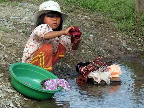 Nhiều trẻ phải mang quần &aacute;o ra suối giặt giũ phụ gi&uacute;p gia đ&igrave;nh v&igrave; cha mẹ, anh chị bận rộn mưu sinh hằng ng&agrave;y