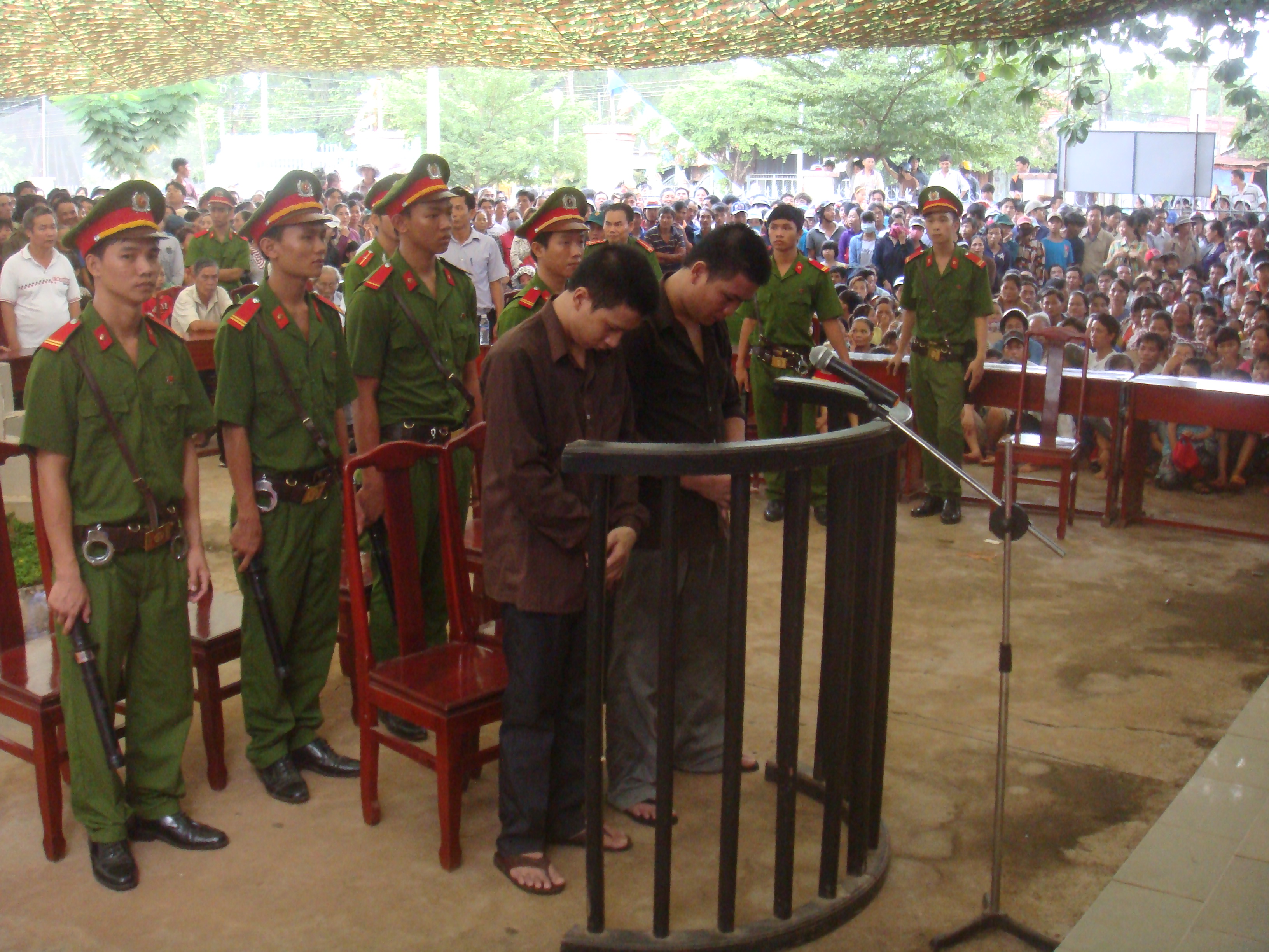 Bị c&aacute;o Đinh Văn Chuy&ecirc;n (b&ecirc;n tr&aacute;i) v&agrave; Đo&agrave;n Quang Lập tại phi&ecirc;n t&ograve;a lưu động s&aacute;ng 6-6, tổ chức xử tại UBND x&atilde; Tiến Hưng, thị x&atilde; Đồng Xo&agrave;i, tỉnh B&igrave;nh Phước. Chuy&ecirc;n bị tuy&ecirc;n tử h&igrave;nh, c&ograve;n Lập chỉ bị 12 th&aacute;ng t&ugrave;.