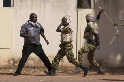 Binh lính chính phủ vung gậy trước người biểu tình ở thủ đô Ouagadougou. Ảnh: Reuters