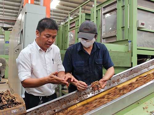 Anh T&ocirc; &Aacute;i Quốc (Nh&agrave; m&aacute;y Thuốc l&aacute; Kh&aacute;nh Hội - b&ecirc;n tr&aacute;i) trong xưởng kiểm tra nguy&ecirc;n liệu