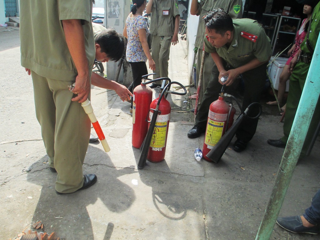 Lực lượng chức năng chuẩn bị bình chữa cháy để cứu hỏa khi hung thủ dọa cho nổ bình gas