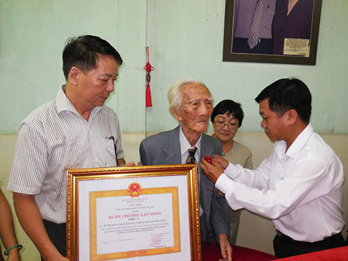Ông Nguyễn Văn Minh - Phó Giám đốc Sở VH, TT và DL TPHCM trao Huân chương lao động hạng ba cho NSND NSND Bảy Bá - soạn giả Viễn Châu Ảnh: Thanh Hiệp