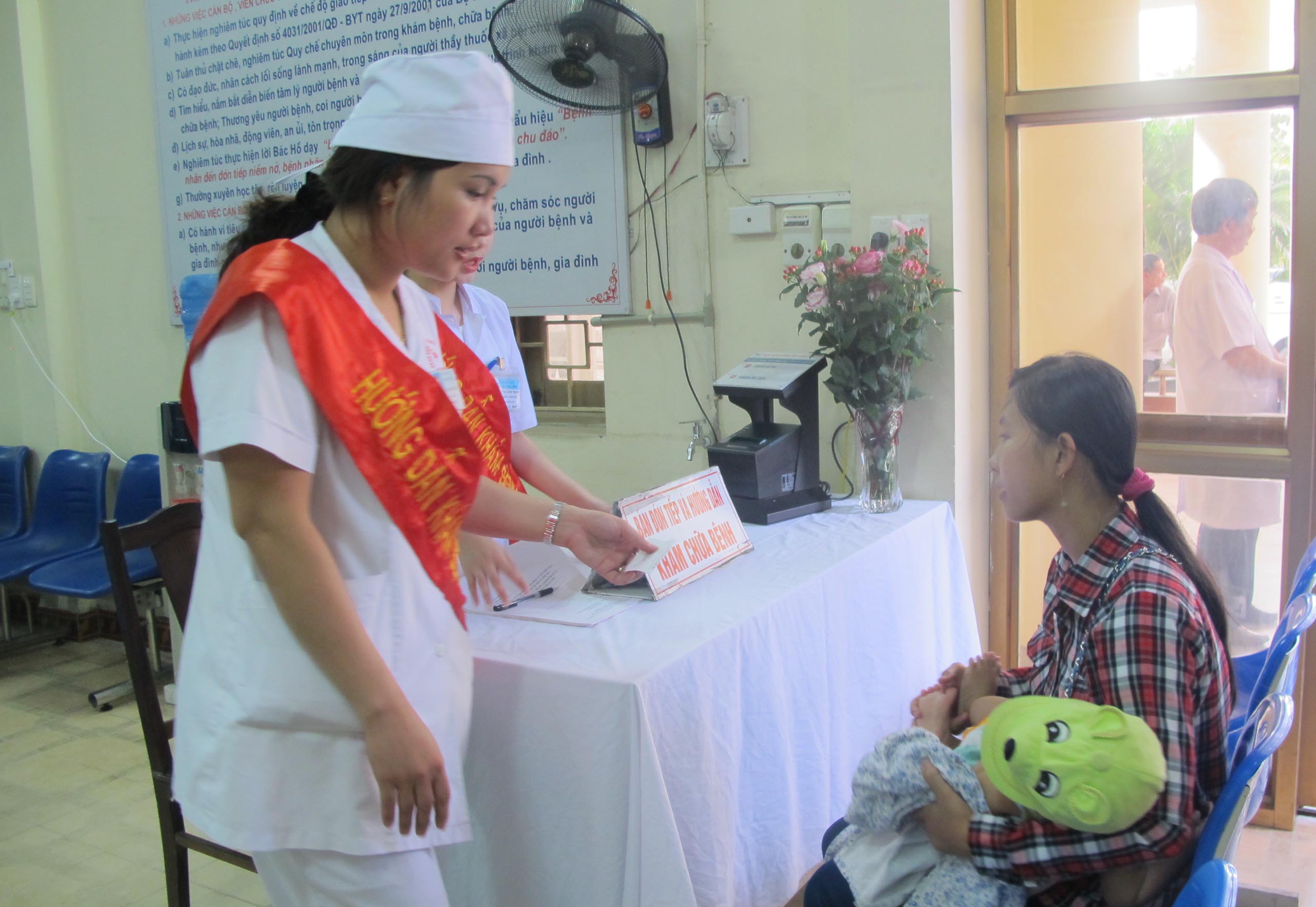 Người d&acirc;n nhận phiếu kh&aacute;m tự động từ nh&acirc;n vi&ecirc;n y tế