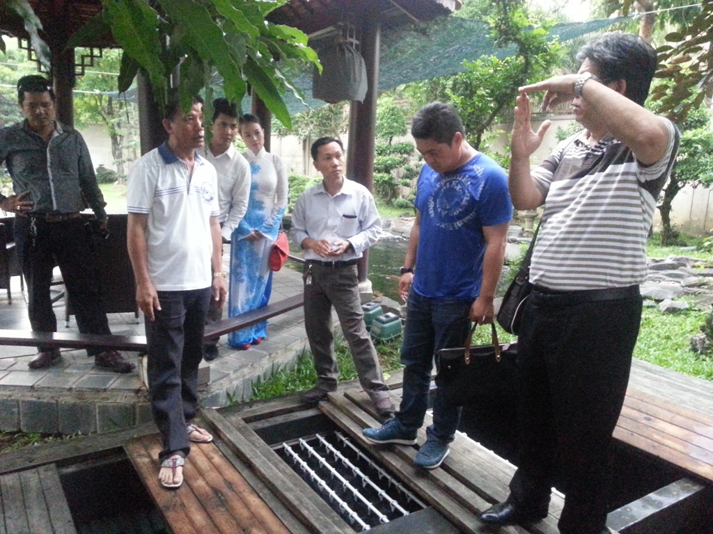 &Ocirc;ng Shigeru Mano (&aacute;o thun xanh) v&agrave; &ocirc;ng Shori Luke đang trao đổi kinh nghiệm cho người chơi c&aacute; Koi.