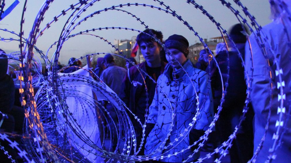 PHOTO: People gather near a barricade with razor wires at the regional administration building in Donetsk, Ukraine, late on April 7, 2014.