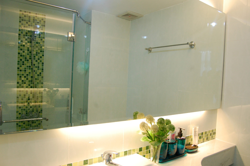 M&agrave;u xanh &ugrave;a v&agrave;o kh&ocirc;ng gian ph&ograve;ng tắm qua những chi tiết trang tr&iacute; giản đơn. Việc giấu nh&agrave; tắm sau tủ quần &aacute;o tạo cảm gi&aacute;c thoải m&aacute;i khi v&agrave;o ph&ograve;ng ngủ.