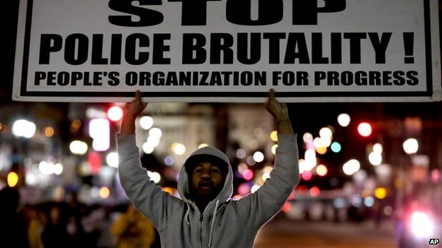 A protester holds a sign reading 