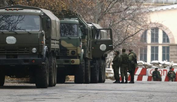 Armed people and military trucks are seen near a checkpoint outside a building on the territory controlled by the self-proclaimed Donetsk Peoples Republic in Donetsk, eastern Ukraine, November 12, 2014. REUTERS/Maxim Zmeyev
